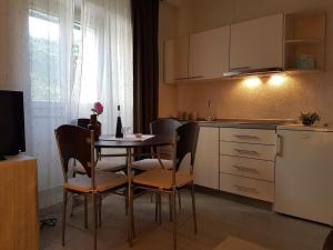 una cucina con tavolo, sedie e frigorifero di Apartment Aduro a Šibenik
