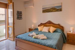 een slaapkamer met een bed met twee knuffels erop bij Casa vacanze santantioco in SantʼAntìoco