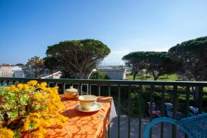 einen Tisch auf einem Balkon mit zwei Tassen und Blumen in der Unterkunft Casa Vacanza La Caletta in La Caletta
