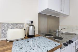 a kitchen with a sink and a stove top oven at Blackberry - Stylish Self-Contained Flats in Soton City Centre in Southampton