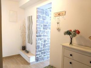 a room with a stone wall with a vase of flowers at APARTMANI Mirona - Tučepi in Tučepi +101 photos