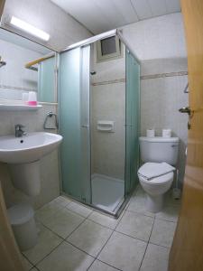 a bathroom with a shower and a toilet and a sink at Crystallo Apartments in Paphos