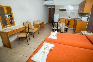 a room with two beds and a kitchen and a table at Crystallo Apartments in Paphos