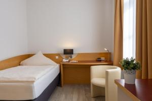 ein Hotelzimmer mit einem Bett und einem Schreibtisch in der Unterkunft Hotel Alte Mühle in Chemnitz