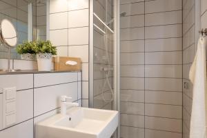 a white bathroom with a sink and a mirror at Hotel Alte Mühle in Chemnitz