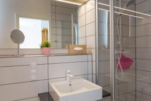 a white bathroom with a sink and a mirror at Hotel Alte Mühle in Chemnitz +5 photos