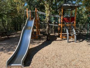 a playground with a slide and a tree at Domaine des Barons de la Chasse -- Eco-Domaine -- Lodge in Bouquet