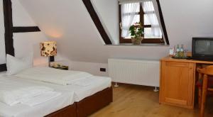 Dormitorio pequeño con cama y TV en Burghotel Volmarstein en Wetter