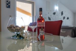 butelkę wina i kieliszek na stole w obiekcie Apartments Lucia Senj w mieście Senj