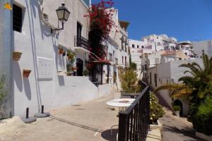 a narrow street with white buildings and a street light at The Town House - Mojacar in Mojácar