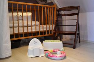 a crib and a chair in a room with a childs bedroom at Ferienhaus _Hasenland_ in Kerkwitz
