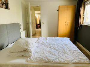 a large white bed in a bedroom with a window at Huisje nummer 3 - No Companies in Goedereede