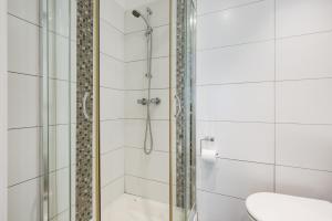 y baño con ducha y puerta de cristal. en KingswayPark Hotel at Park Avenue en Londres
