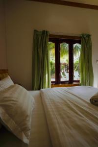 a bedroom with two beds and a window at Veli Beach Inn in Mathiveri