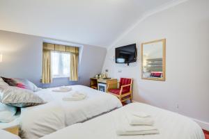 1 dormitorio con 2 camas, escritorio y TV en KingswayPark Hotel at Park Avenue, en Londres