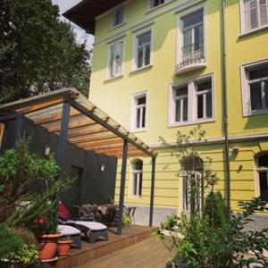 a yellow building with a pergola in front of it at Hotel Villa Laurel in Lovran