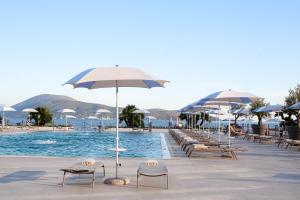a swimming pool with chairs and umbrellas and a swimming pool at Palmon Bay Hotel & Spa in Herceg-Novi