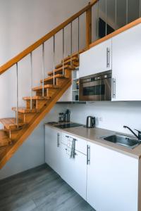 a kitchen with white cabinets and a staircase at Brother House Kaunas in Kaunas