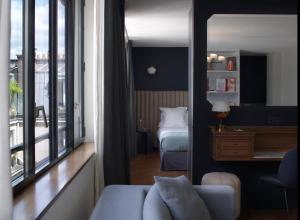 a room with a bedroom with a bed and a mirror at Hotel Bachaumont in Paris
