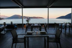 a restaurant with tables and chairs and a view of the water at Palmon Bay Hotel & Spa in Herceg-Novi