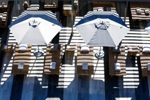 two umbrellas sitting on chairs next to a pool at Palmon Bay Hotel & Spa in Herceg-Novi