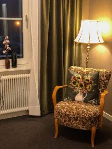 Villa Bergli في مالونك: جلسة مصباح بجانب كرسي مع مخدة