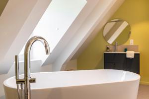 a bathroom with a white tub and a sink at Le Prieuré Saint-Malo de Dinan in Dinan