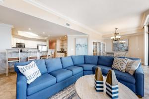 um sofá azul numa sala de estar com uma mesa em Phoenix West II #609 em Orange Beach