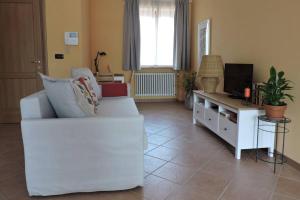 uma sala de estar com um sofá branco e uma televisão em Cascina in Alto Piemonte / Piedmont countryhouse em Lozzolo
