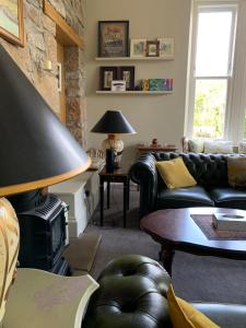 a living room with a couch and a fire place at Creity Hall Guest House in Doune