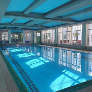 duży basen z niebieską wodą w budynku w obiekcie Klub Sosnowy w Warszawie