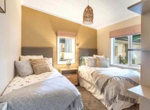 2 camas en una habitación con 2 ventanas en Bude Holiday Resort en Bude