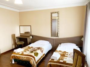 a hotel room with two beds and a mirror at Ranczo w Dolinie in Dobre Miasto