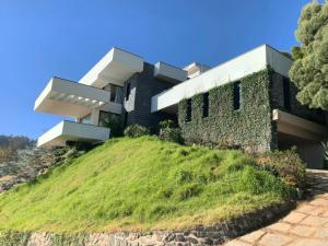 a building on top of a hill with grass at amã Stays & Trails Kailash House in Kodaikānāl