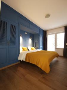 オーステンデにあるVakantieaanzee21の青いベッドルーム(黄色い毛布付きのベッド付)