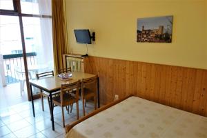 1 dormitorio con mesa, cama y TV en Résidence thermale de Vernet-les-Bains, en Vernet-les-Bains