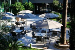 a group of tables and chairs with umbrellas at Palmon Bay Hotel & Spa in Herceg-Novi