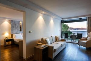 a living room with a couch and a bed and a window at Palmon Bay Hotel & Spa in Herceg-Novi