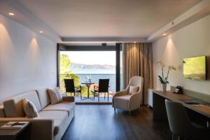 a living room with a couch and a table with chairs at Palmon Bay Hotel & Spa in Herceg-Novi
