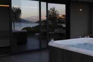 a bathroom with a tub and a view of the water at Palmon Bay Hotel & Spa in Herceg-Novi