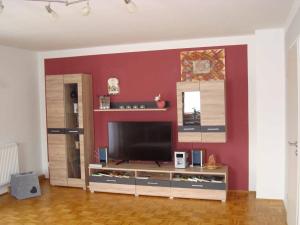 sala de estar con TV de pantalla plana en la pared en Ferienwohnung Gabi, en Piding