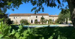 an exterior view of a large house with a swimming pool at Domaine du Papillon in Lesparre-Médoc
