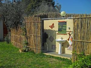 Camping Terreno-Ro-Bi-Li في كوتروفيانو: حمام مع حوض ومرحاض في سياج