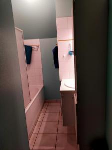 a bathroom with a sink and a tub and a toilet at La petite maison bleue in Lopérec
