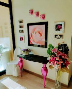 una mesa con un jarrón de flores en una habitación en Hotel Alcazar, en Rímini