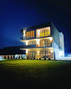 a large building with lights on it at night at Papa Apartments in Berovo