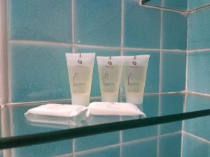 two cups on a glass shelf in a bathroom at Rotondo Residence - Simar Vacanze in Porto Rotondo +42 photos