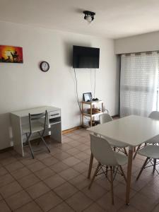 a living room with a table and chairs and a television at Apartamento Pacifico Suites Centro in Bahía Blanca