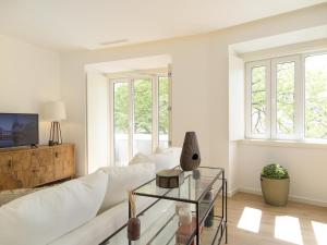 a living room with a white couch and a glass table at Eduardo vii park great bright apt with ac elevator in Lisbon