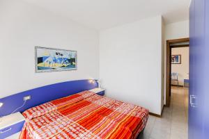 um quarto com uma cama com um edredão colorido em Tamerici Lido Altanea em Caorle